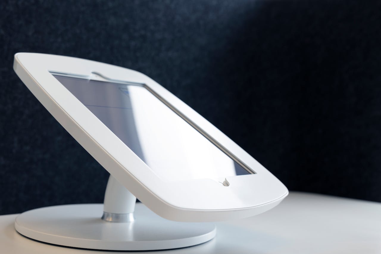 about-01 Close-up of a sleek tablet stand on a table, showcasing modern design in technology.