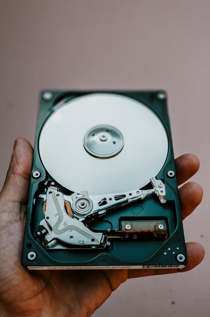 home-services-03 Close-up view of an open hard drive held in a hand, illustrating data storage technology.